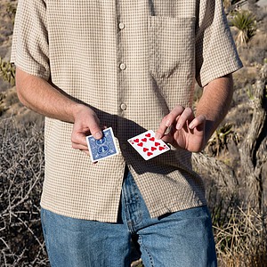 2 Card Monte magic trick - the magician displaying the blue-backed card and the Ten of Hearts during the demonstration