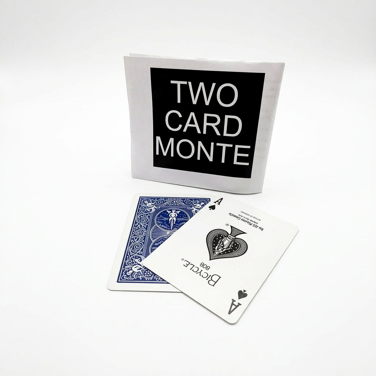 2 Card Monte magic trick - the instruction packet and two Bicycle playing cards arranged on a white background