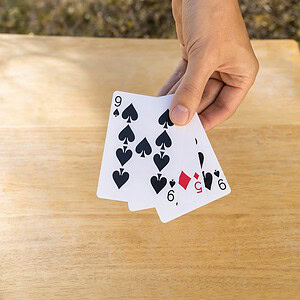3 Card Monte magic trick - the magician fanning the three playing cards in hand during the demonstration