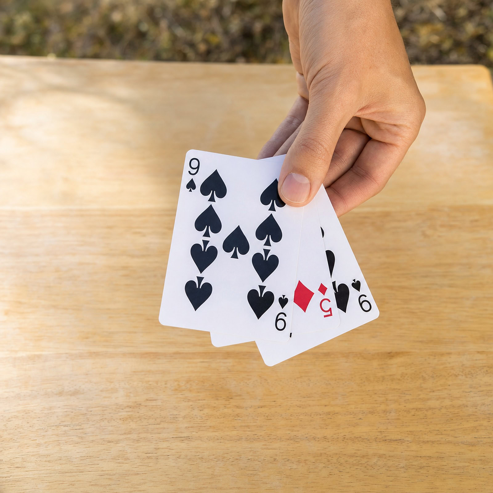3 Card Monte magic trick - the magician fanning the three playing cards in hand during the demonstration
