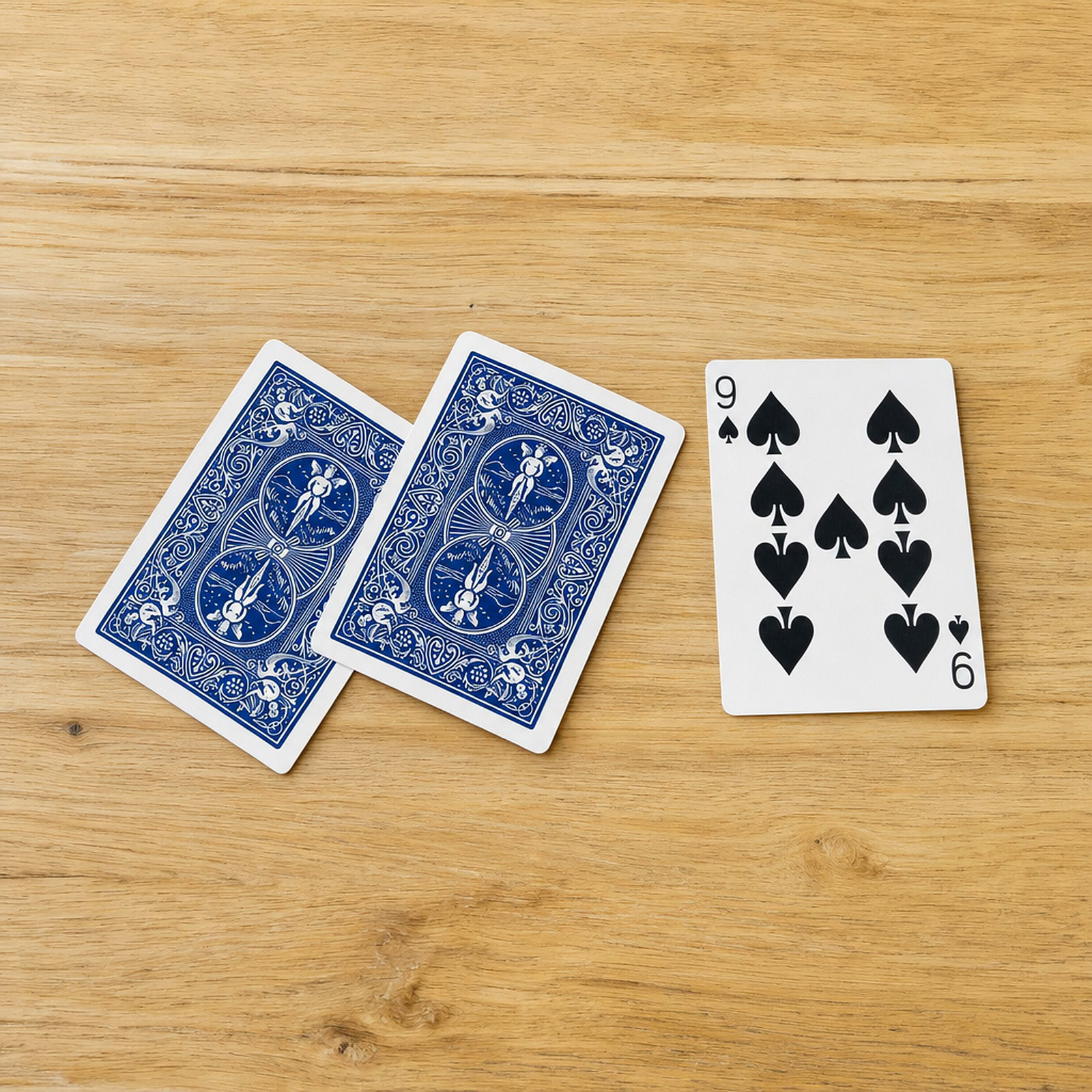 3 Card Monte magic trick - the three cards laid out on the table with the face card revealed