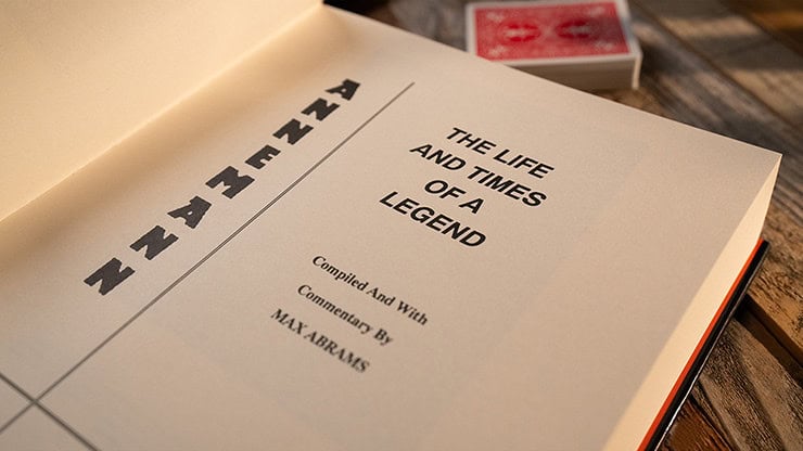A captivating open book titled "The Life and Times of a Legend" with a deck of playing cards nearby.
