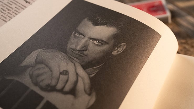 A man with intense gaze and clenched fist, black and white portrait.