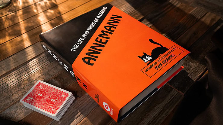 A colorful book titled "The Life and Times of Fritz" by Annemann with a black and orange cover, plac.