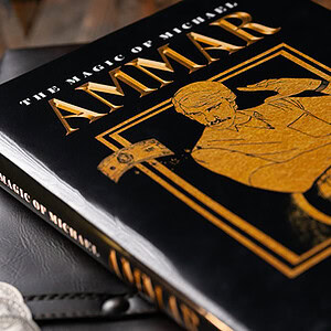Elegant magician performing a card trick with a black and gold magic book in the background.
