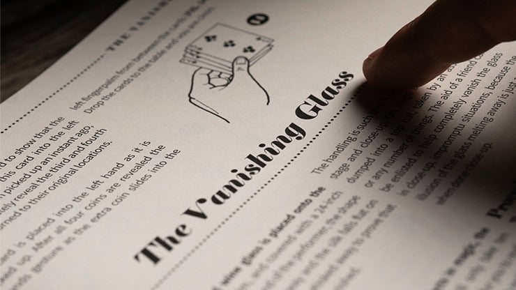 Close-up of a finger pointing at a diagram of a vanishing glass on a printed page.
