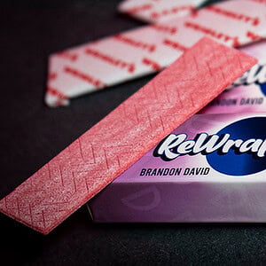 Relwrapped candy bar with pink and purple packaging on black background.
