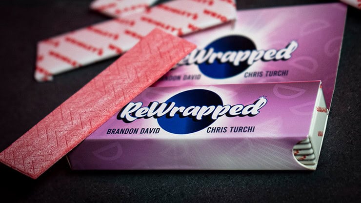 Relwrapped candy bar with pink and purple packaging on black background.