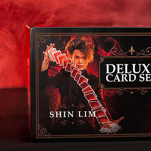 Deluxe card set featuring a magician performing a card trick with red smoke background.