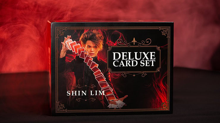 Deluxe card set featuring a magician performing a card trick with red smoke background.