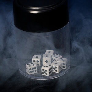 Dice inside a glass container with smoke for magic trick.