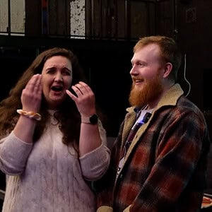 A woman reacting with surprise and excitement during a magic performance at Dreamlandmagic.