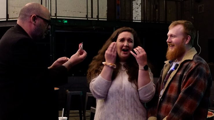 A woman reacting with surprise and excitement during a magic performance at Dreamlandmagic.
