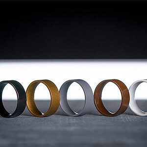Black, gold, gray, brown, and white rings arranged in a row on a dark background.