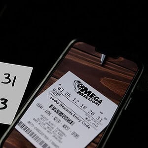 Lottery ticket and handwritten numbers on paper, close-up image.