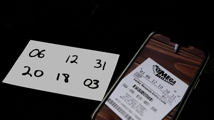 Lottery ticket and handwritten numbers on paper, close-up image.