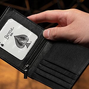 Close-up of a black wallet with an ace of spades playing card inside.