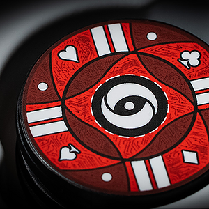 Red poker chip with black and white symbols and a spiral design in the center.