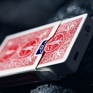 A deck of red-backed playing cards performing a levitation trick.