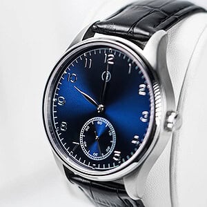 Elegant blue watch with black leather strap, showcasing a sleek design and precise timekeeping.