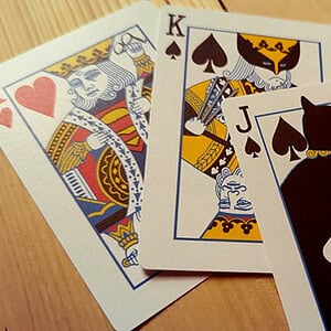 A deck of playing cards featuring king, queen, jack, and ace cards with a royal and magical theme.
