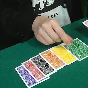A colorful arrangement of playing cards on a green table, part of a magic performance.