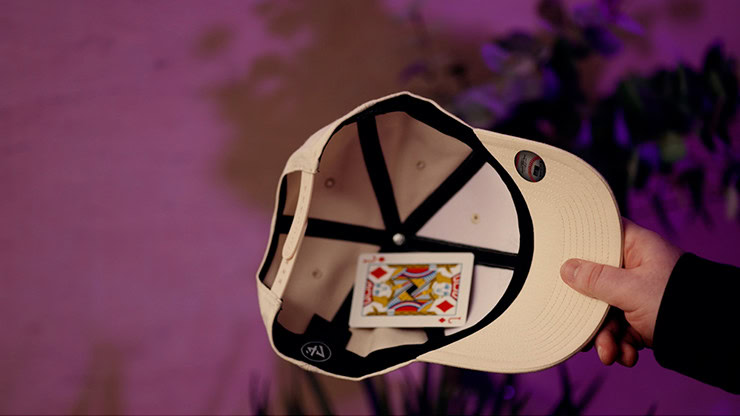 Close-up of a beige baseball cap with a colorful card inside the brim.