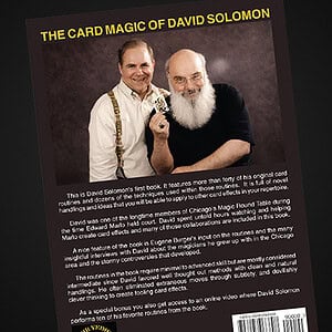 A man performing a card magic trick with David Solomon, showcasing close-up magic and mentalism.