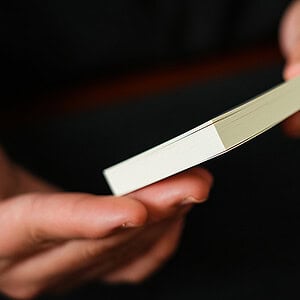 A magician performing a card trick with a deck of cards.