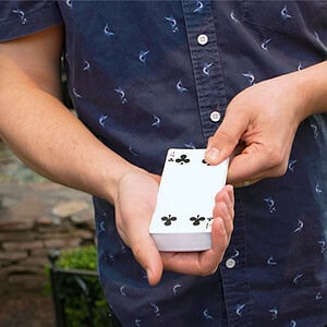 A colorful deck of playing cards being fanned out by a person outdoors.
