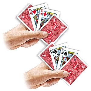 Close-up of hands holding a fan of playing cards for magic tricks.