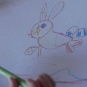 Child's colorful drawing of a bunny with blue eyes and long ears.
