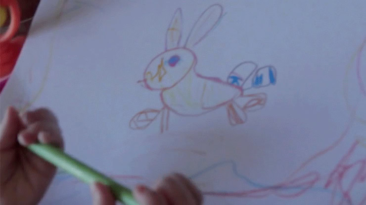 Child's colorful drawing of a bunny with blue eyes and long ears.