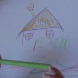 Child's colorful drawing of a house and a person with a green crayon.