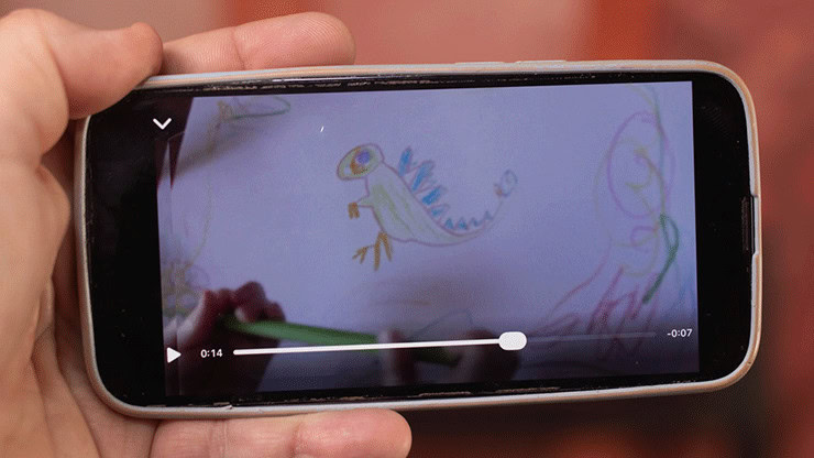 Child's drawing of a colorful dinosaur on a smartphone screen.