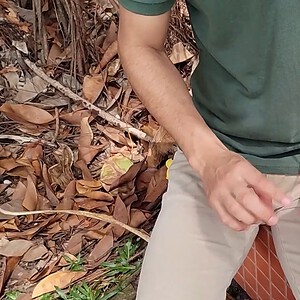 Close-up of a person performing an Ambitious card trick outdoors with autumn leaves.