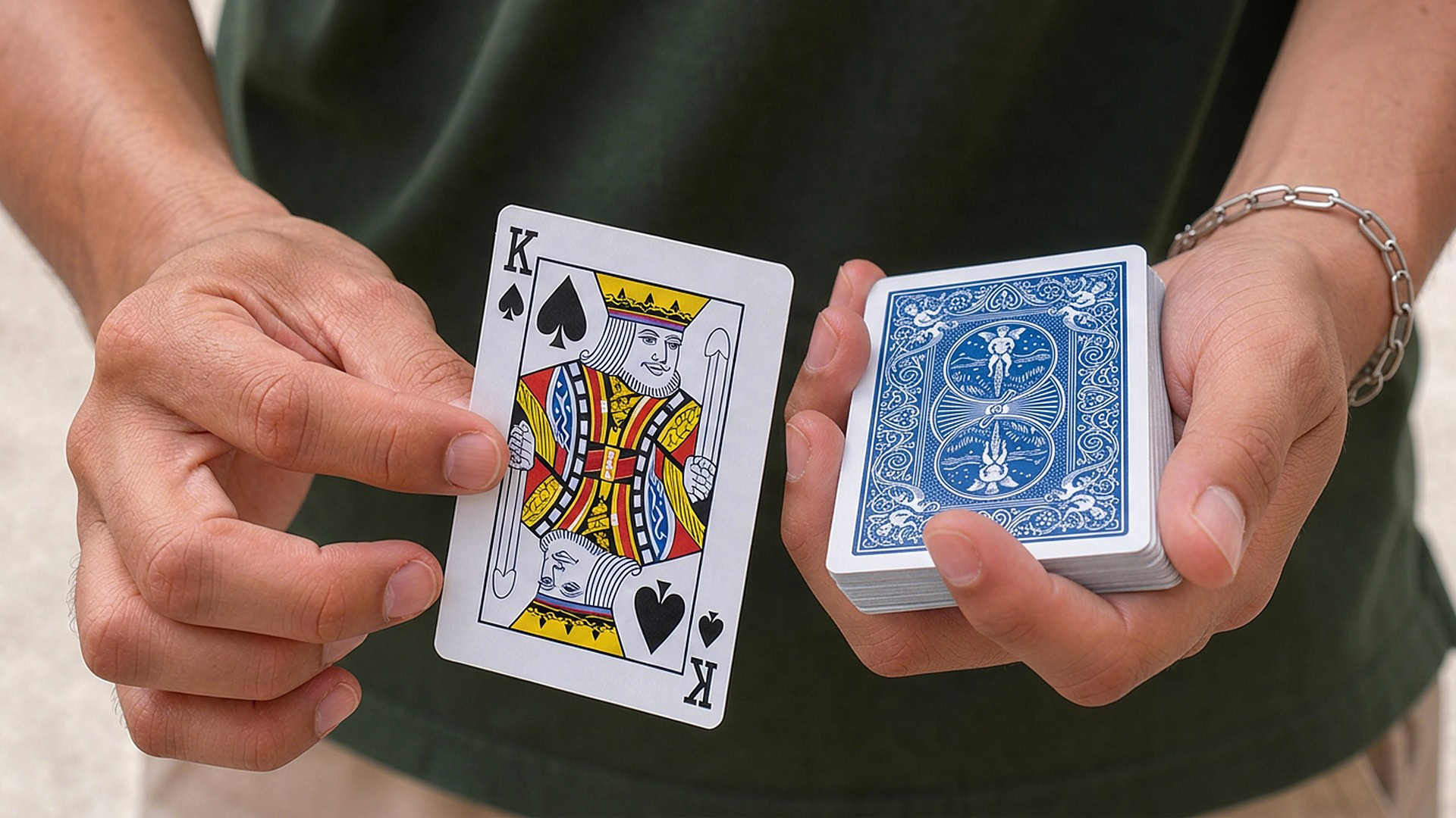 Card Ambitious by Kenneth Costa magic trick - performer revealing the chosen card with a blue deck on an outdoor balcony