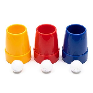 Cups and Balls Plastic magic trick - the three cups stood upright in a row with a white pom-pom ball in front of each