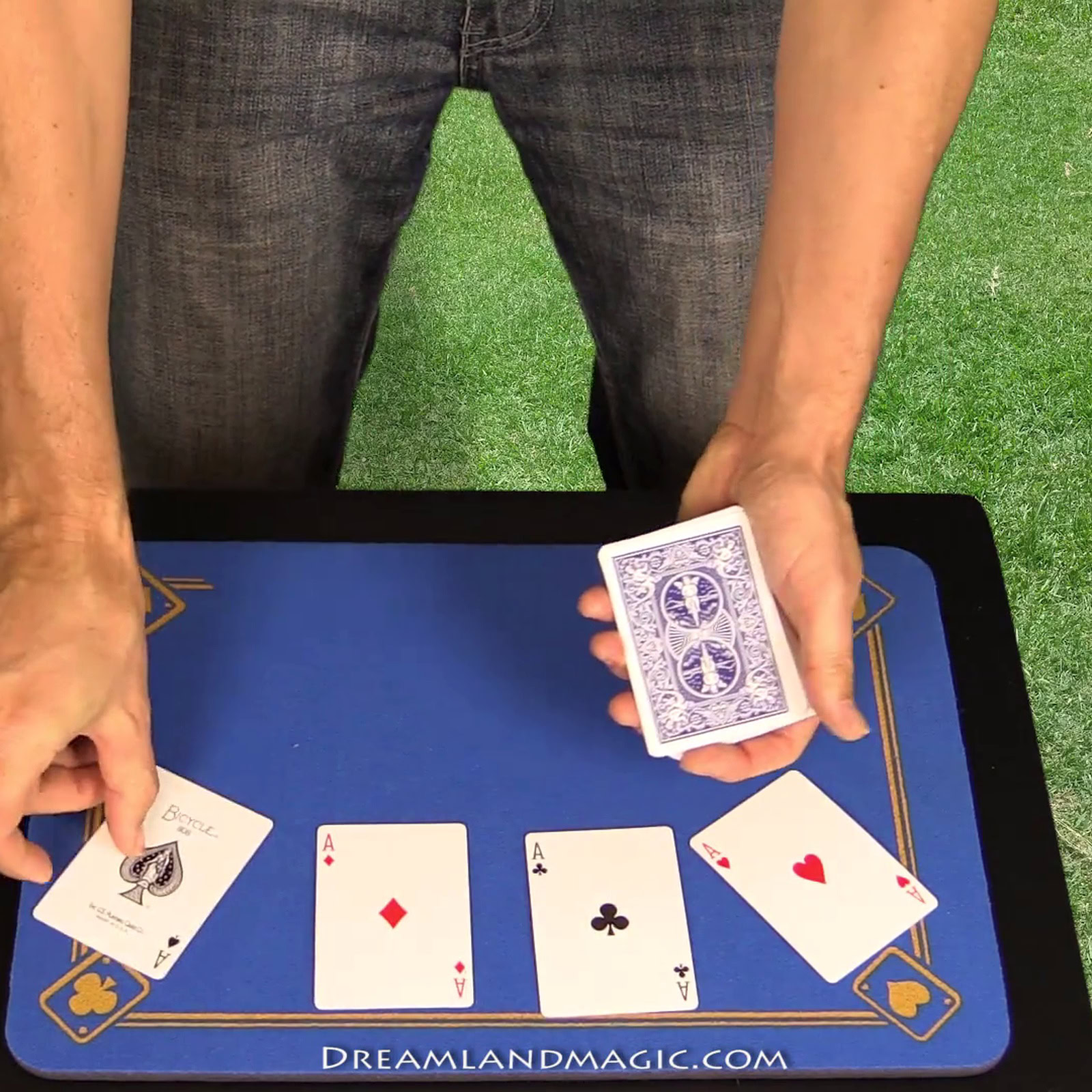 Magician performing card trick with four aces on a magic table.