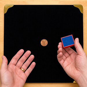 Magical Block penny to dime trick — copper penny on the velvet close-up pad with the red block held ready