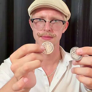 OneFly by Pieter Hofstra coin magic tutorial - magician displaying two silver coins