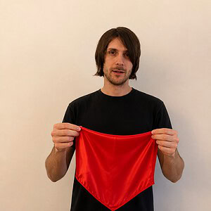 Vanishing Silk Magic Trick - magician displaying the bright red silk handkerchief before the vanish